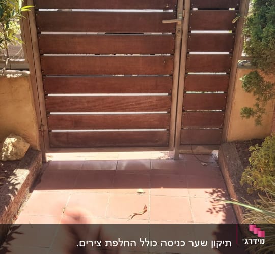 שער עץ חום עם מסגרת מתכת בגינה